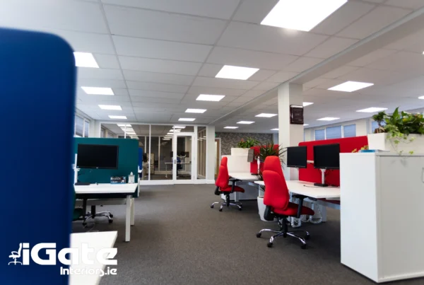Hot desking office with shared workstations, ergonomic chairs and screened desk areas in a modern open-plan workspace.