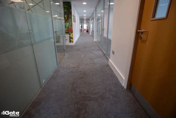 Grey office carpet tiles in a modern corridor with glass partitioned offices